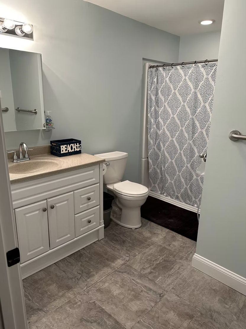 Modern bathroom renovation with white vanity and gray tile