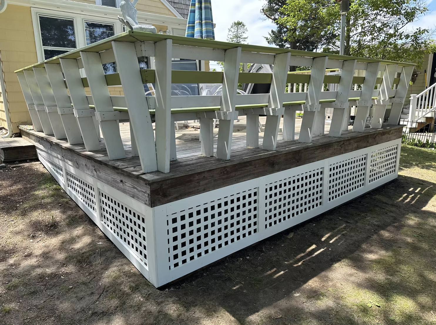 Large outdoor deck with white railings and lattice skirting